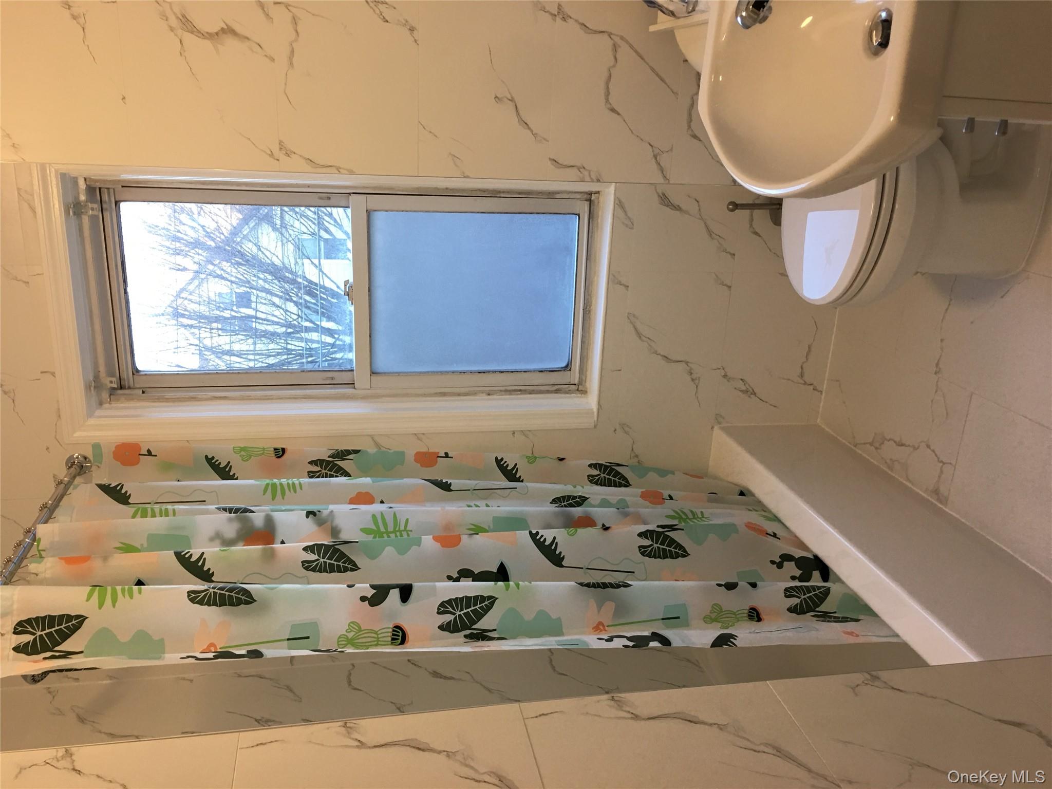 37-54 99th Street Queens, NY 11368 - Photo 9 of 18 a bathroom with a bathtub and window