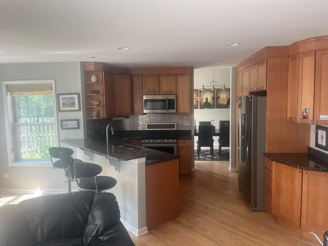 a kitchen with granite countertop a refrigerator stove and oven