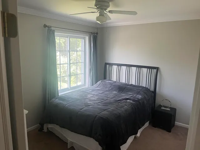 a bed sitting in a bedroom next to a window