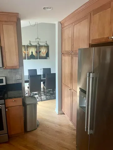 a kitchen with stainless steel appliances granite countertop a refrigerator a stove a sink and a refrigerator