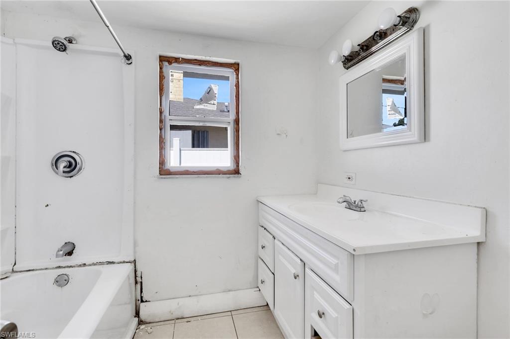 5326 Dixie Drive Naples, FL 34113 - Photo 16 of 25 a bathroom with a sink a mirror and a bathtub