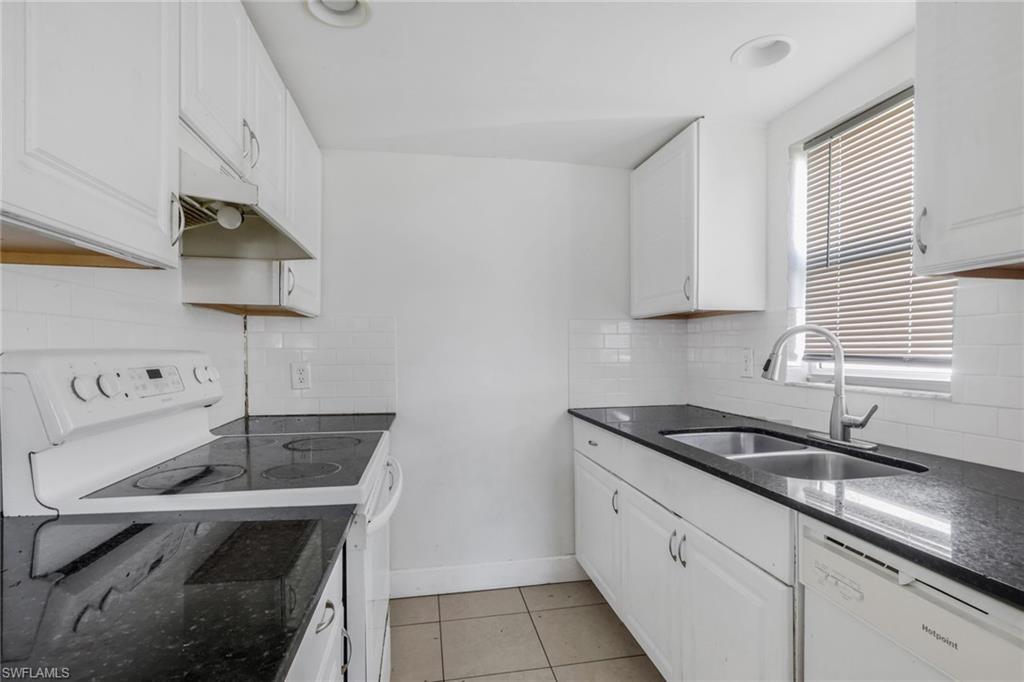 5326 Dixie Drive Naples, FL 34113 - Photo 5 of 25 a kitchen with a sink cabinets and a stove top oven