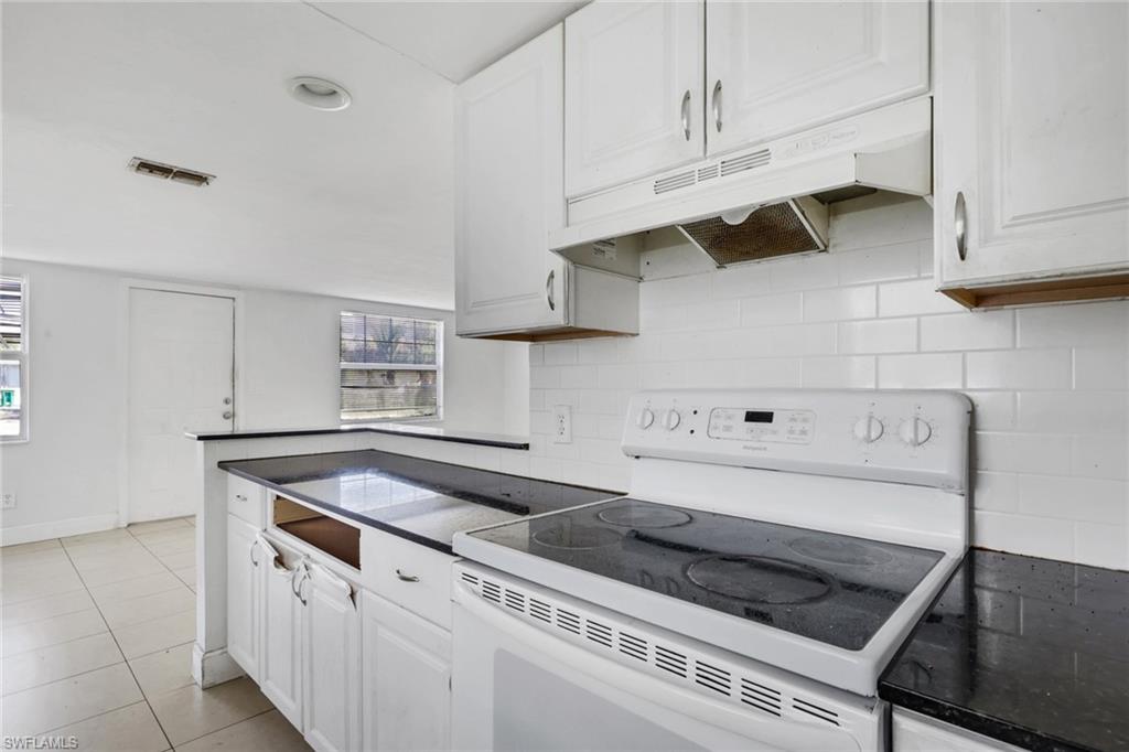 5326 Dixie Drive Naples, FL 34113 - Photo 6 of 25 a kitchen with white cabinets and appliances
