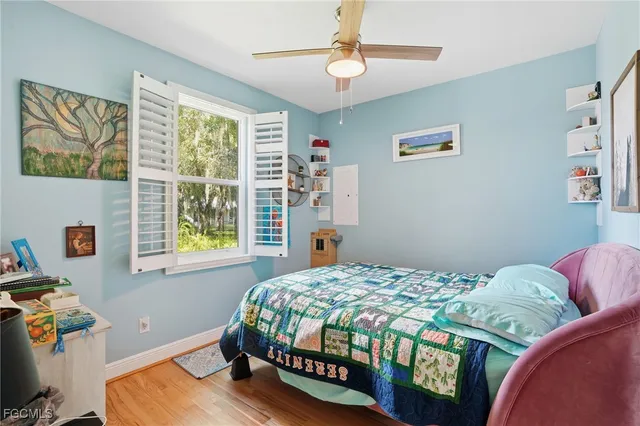 a bedroom with a bed painting on wall and a window