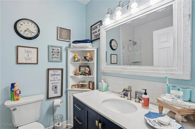 a bathroom with a sink mirror vanity and toilet