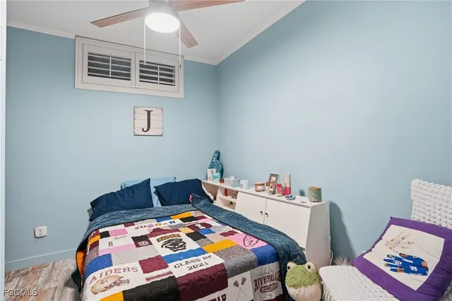 a bedroom with a bed and a lamp on dresser