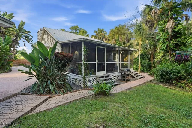 a view of a chair and table in backyard of the house