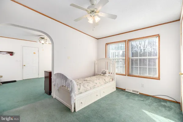 a bedroom with a bed next to a window