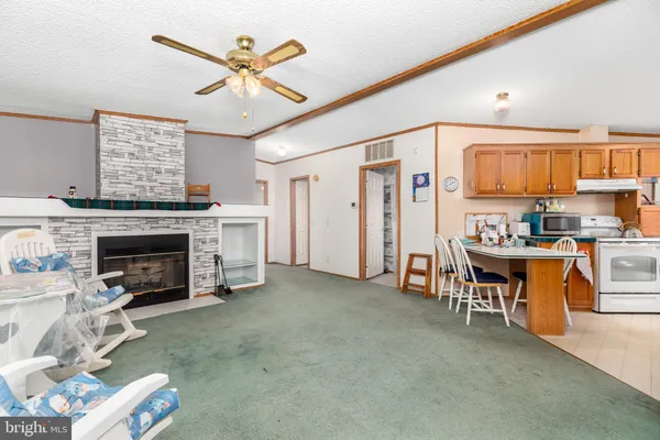a living room with furniture a fireplace and kitchen view