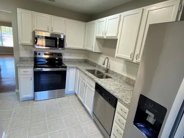 a kitchen with stainless steel appliances granite countertop a stove microwave and sink