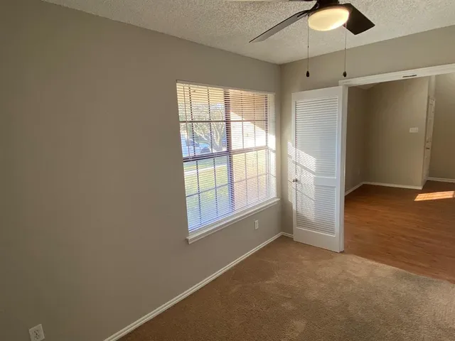 an empty room with windows and closet