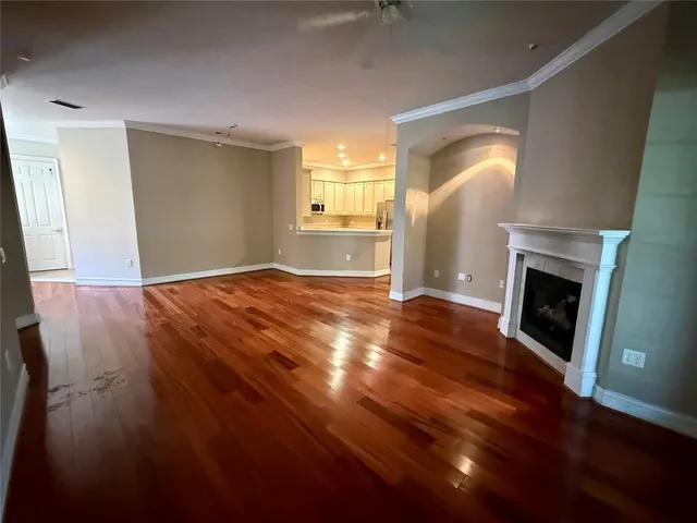 a view of empty room with wooden floor and fireplace