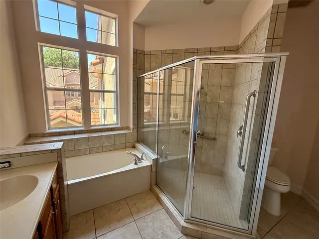 a bathroom with a tub shower and toilet