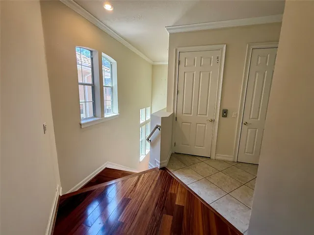 a view of a hallway with wooden floor and staircase