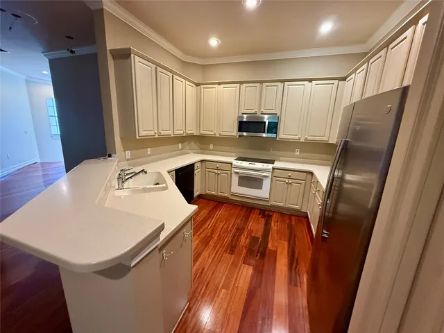 a kitchen with sink refrigerator and microwave