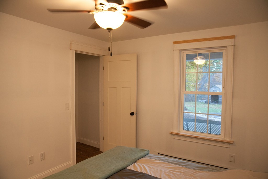 240 North Brookfield Road Oakham, MA 01068 - Photo 13 of 24 an empty room with wooden floor fan and windows