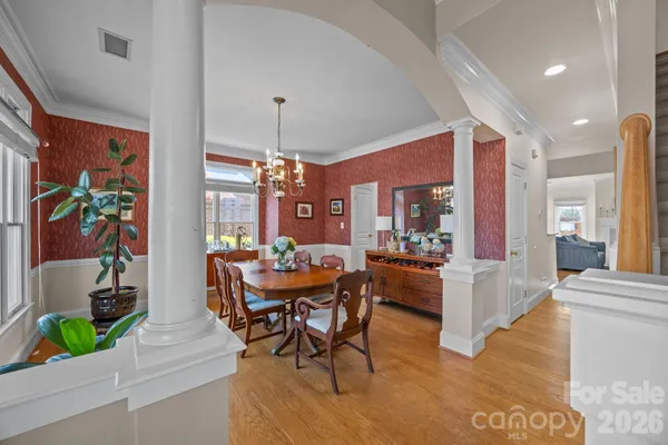 a dining room with furniture a chandelier and wooden floor
