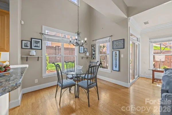 a dining room with furniture a chandelier and wooden floor