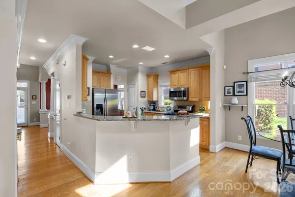 a kitchen with stainless steel appliances granite countertop a refrigerator and a stove top oven