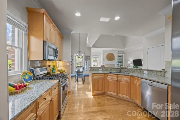 a kitchen with stainless steel appliances granite countertop a sink stove and cabinets
