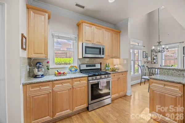 a kitchen with stainless steel appliances granite countertop a stove a sink and a microwave
