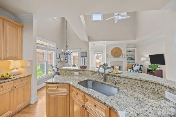 a kitchen with granite countertop a sink a counter top space and stainless steel appliances