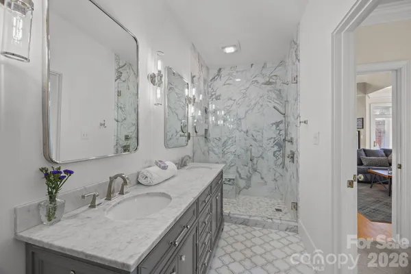a bathroom with a granite countertop shower sink and mirror