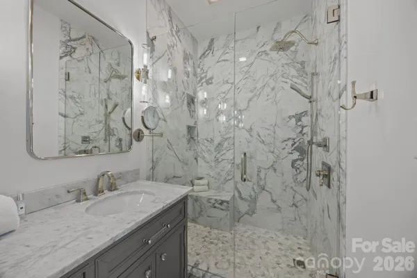 a bathroom with a granite countertop sink and a shower