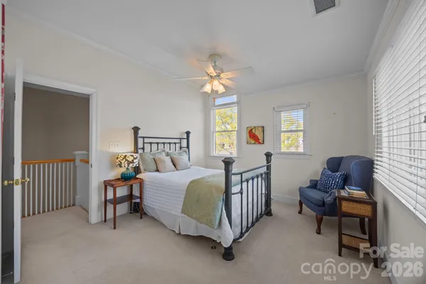 a bedroom with a bed chair and windows