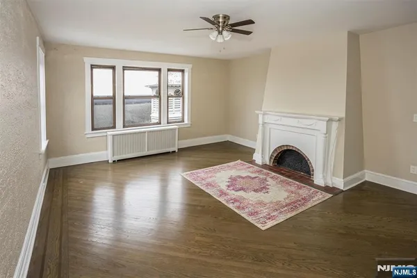 a living room with a rug wooden floor and a fireplace