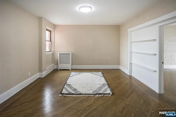 an empty room with wooden floor and window