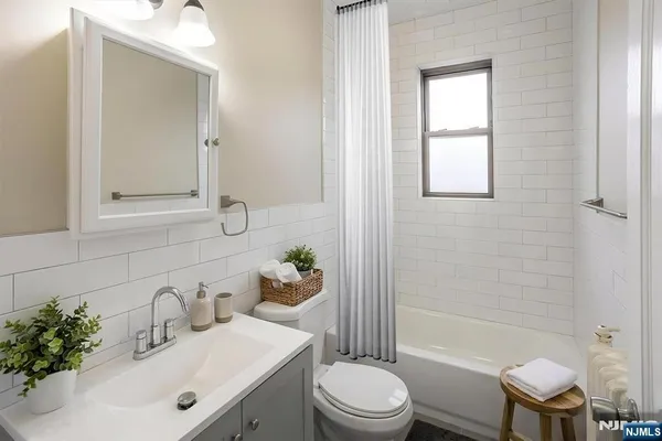 a bathroom with a sink toilet a mirror and shower