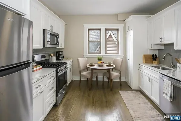 a kitchen with a refrigerator and a stove top oven