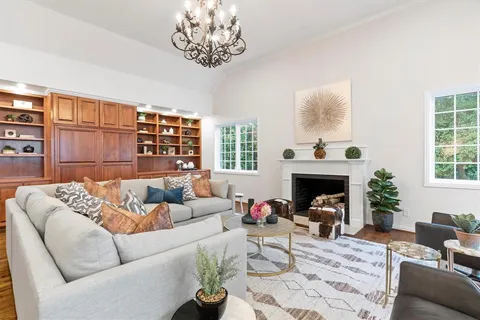 a living room with furniture a chandelier and a fireplace