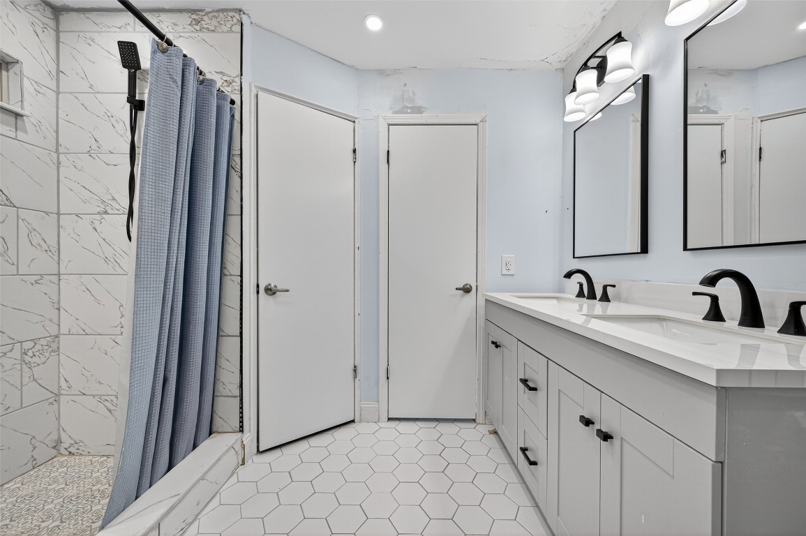 202 Laura Lane Conroe, TX 77385 - Photo 28 of 31 a bathroom with a double vanity sink and mirror
