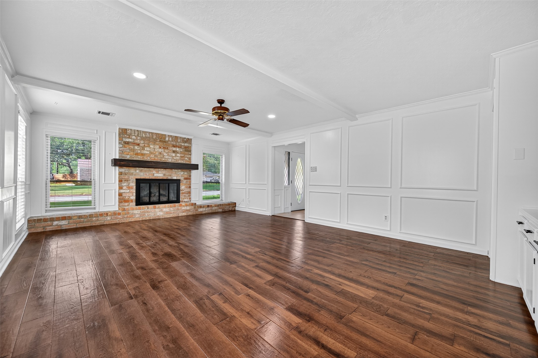 202 Laura Lane Conroe, TX 77385 - Photo 5 of 31 a view of an empty room with wooden floor fireplace and a window