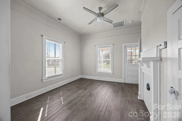 a view of empty room with a window and wooden floor