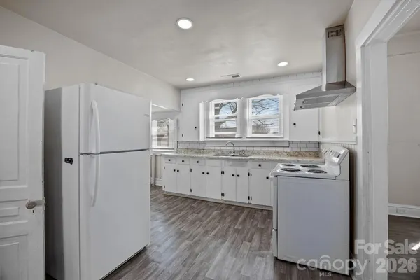 a kitchen with stainless steel appliances granite countertop a refrigerator and a stove top oven