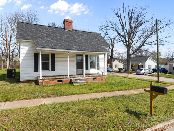 a front view of a house with swimming pool and a yard