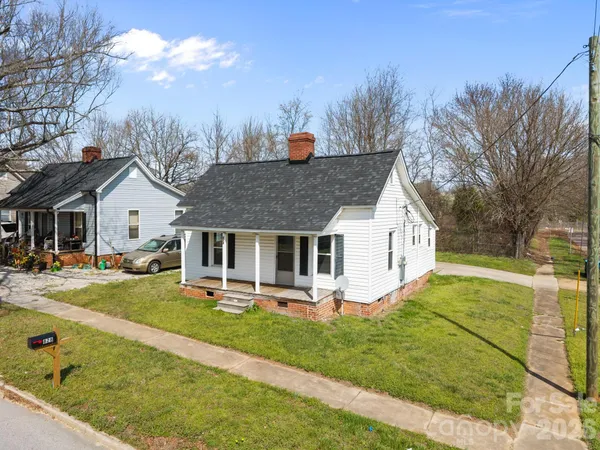 a view of a house with backyard and a tree