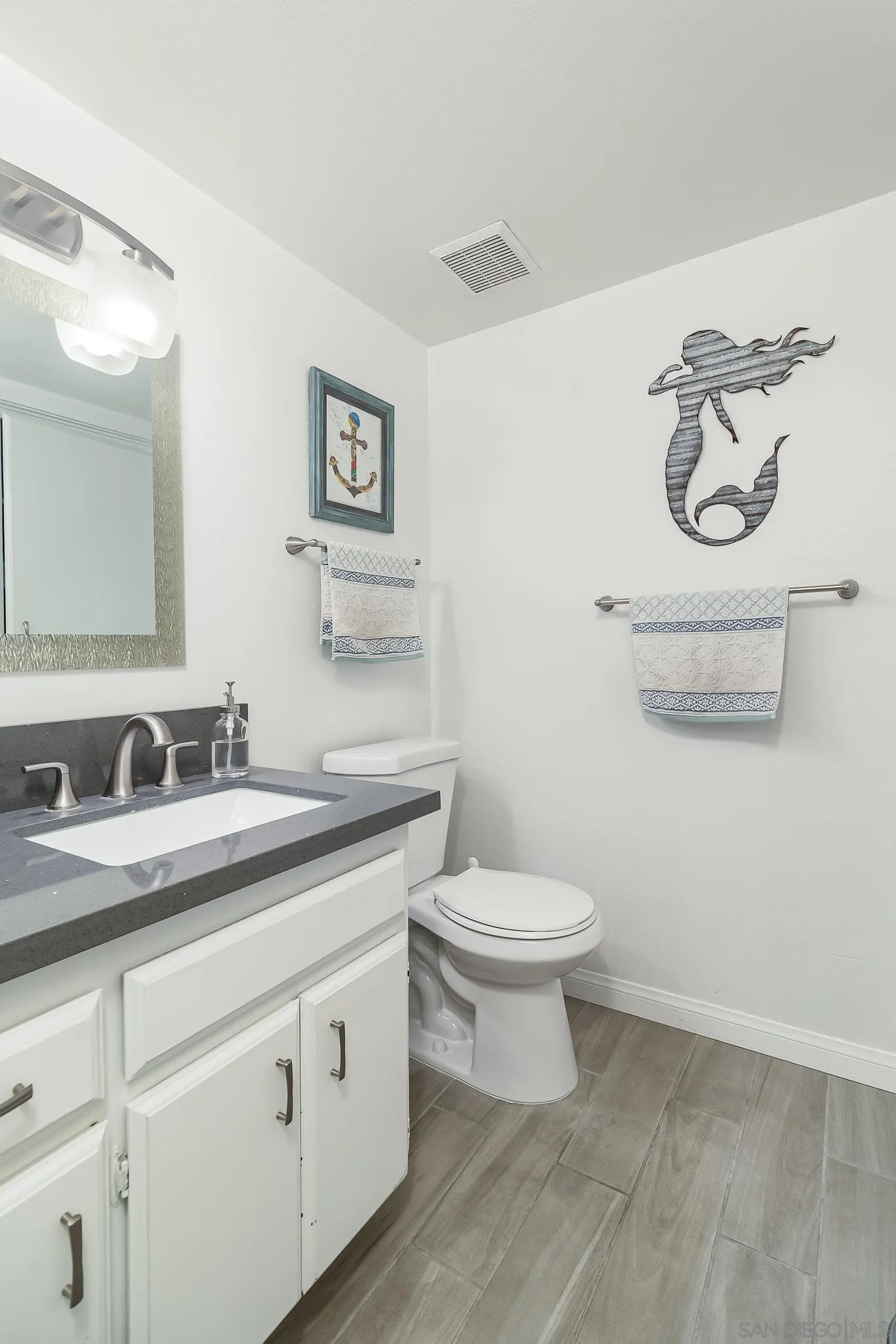 350 G Street, Unit E2 Chula Vista, CA 91910 - Photo 15 of 30 a bathroom with a toilet a sink and mirror