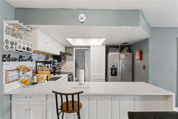 a kitchen with a sink a stove and chairs