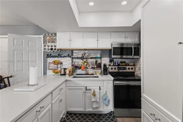 a kitchen with kitchen island a sink stainless steel appliances and cabinets