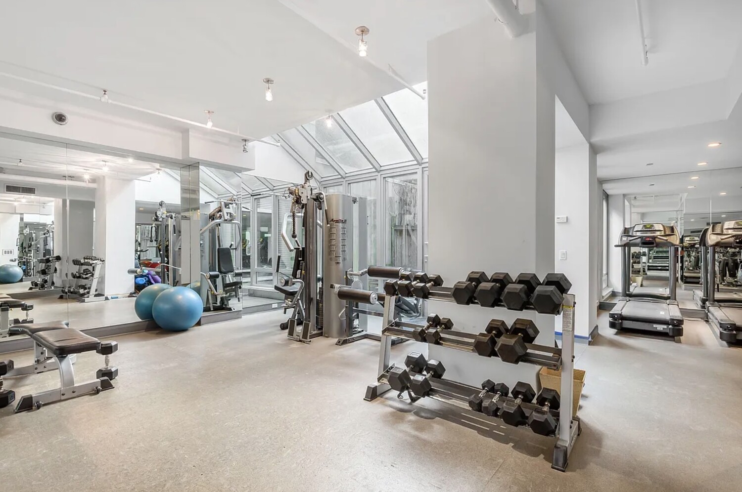 165 West 18th Street, Unit 3C Manhattan, NY 10011 - Photo 9 of 12 a living room with furniture and gym equipment