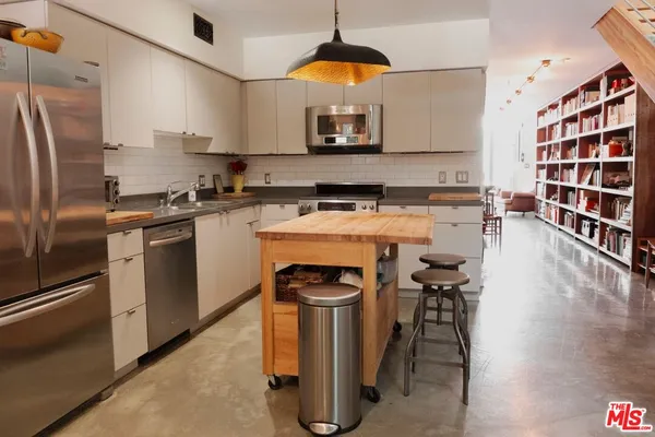 a kitchen with stainless steel appliances granite countertop a stove a sink and a refrigerator