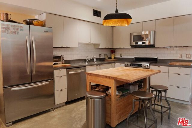 a kitchen with stainless steel appliances a stove a refrigerator and a sink
