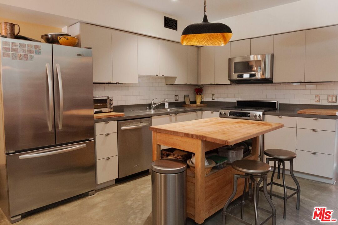 700 Main Street, Unit 12 Venice, CA 90291 - Photo 5 of 27 a kitchen with stainless steel appliances a stove a refrigerator and a sink