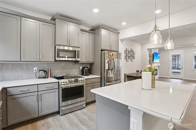 a kitchen with a sink a counter space appliances and cabinets