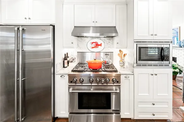 a kitchen with stainless steel appliances granite countertop a stove and a refrigerator