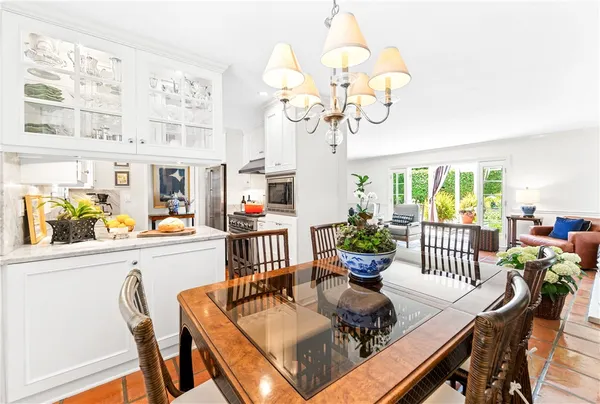 a view of a dining room with furniture a chandelier and wooden floor
